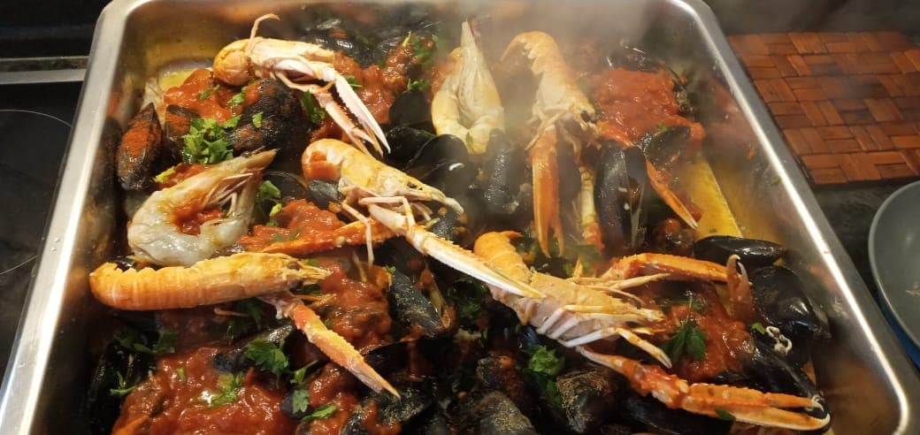 Langoustines, prawns and mussels in tomato, steaming in the tray